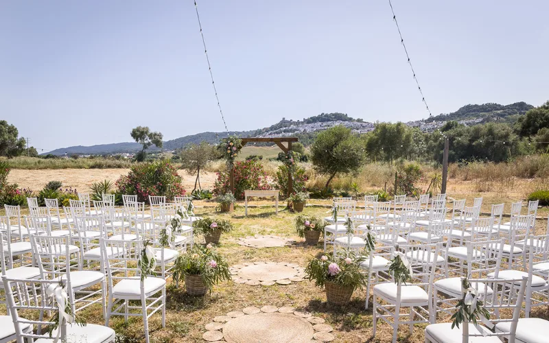 Ceremony chairs set out on open ground with mountains behind