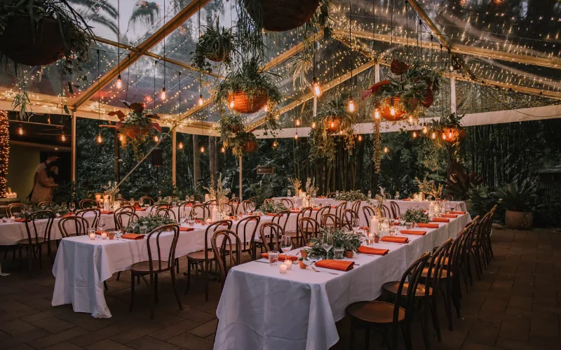 Long tables set under a marquee lit for the evening