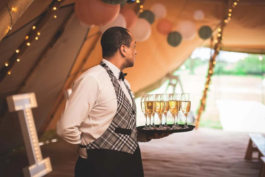 Bartender serving drinks from a bar at an outdoor event