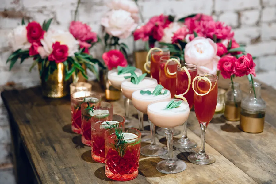 Dessert and drinks table styled with pink flowers at a wedding